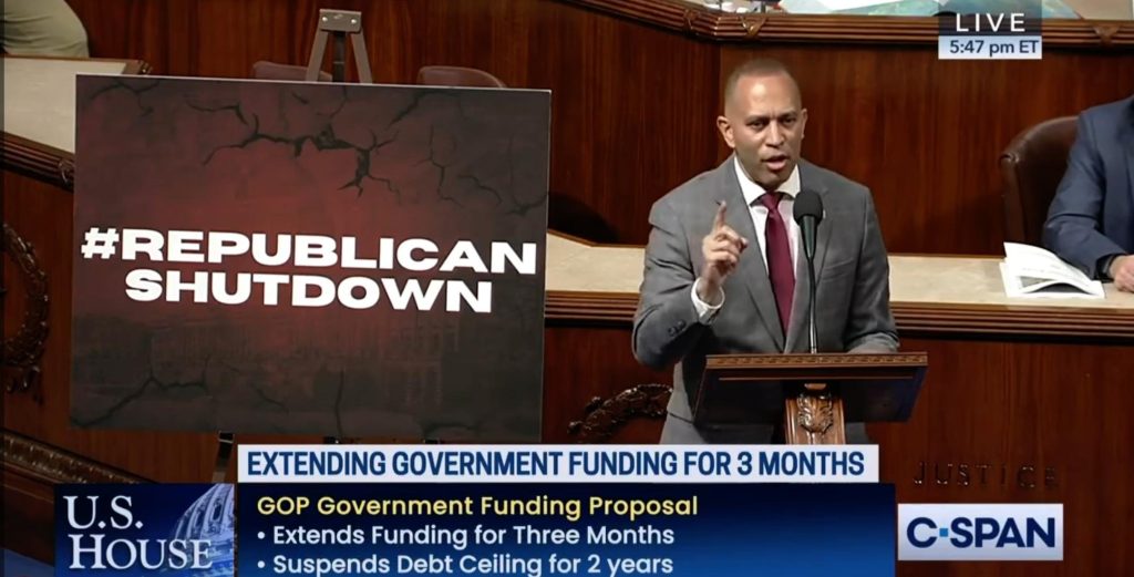 Leader Jeffries speaking on the House Floor, next to a poster reading #RepublicanShutdown